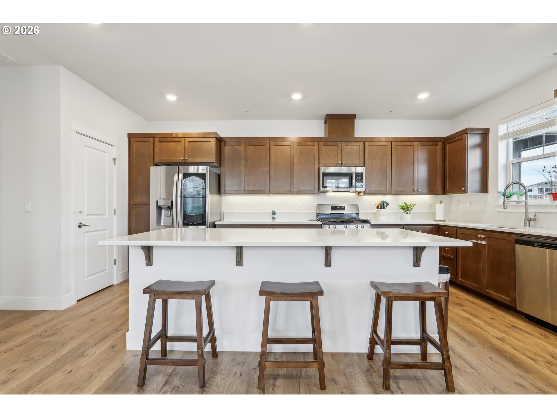 18436 Southwest Buckhorn Drive Beaverton, OR 97007 - Photo 12 of 35 a kitchen with stainless steel appliances granite countertop a table chairs refrigerator and sink