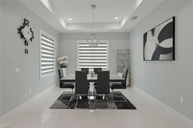 a kitchen with stainless steel appliances granite countertop a refrigerator a stove top oven and a dining table view