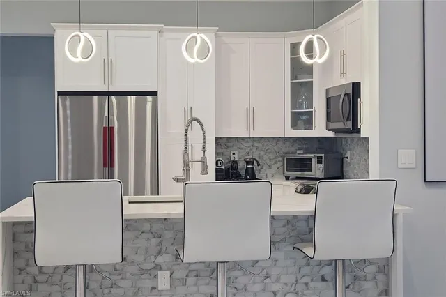 a kitchen with stainless steel appliances granite countertop a fireplace a stove a sink and dishwasher