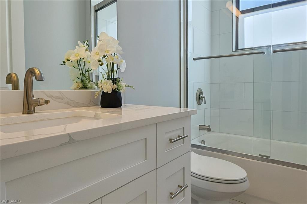 2330 4th Avenue Southeast Naples, FL 34117 - Photo 33 of 43 a bathroom with a granite countertop sink a toilet and shower