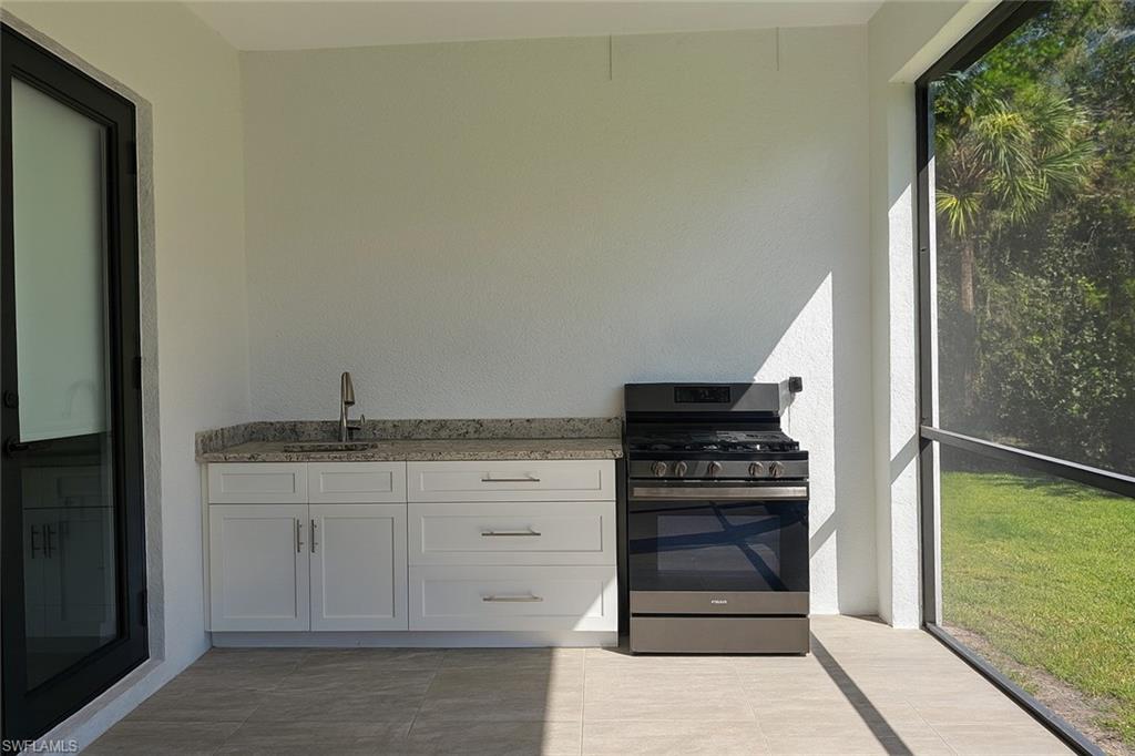2330 4th Avenue Southeast Naples, FL 34117 - Photo 39 of 43 a kitchen with granite countertop a refrigerator and a stove