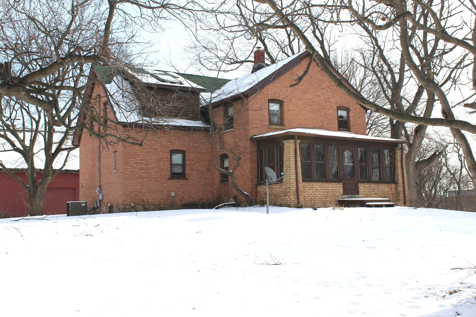a front view of a house with a yard covered in snow