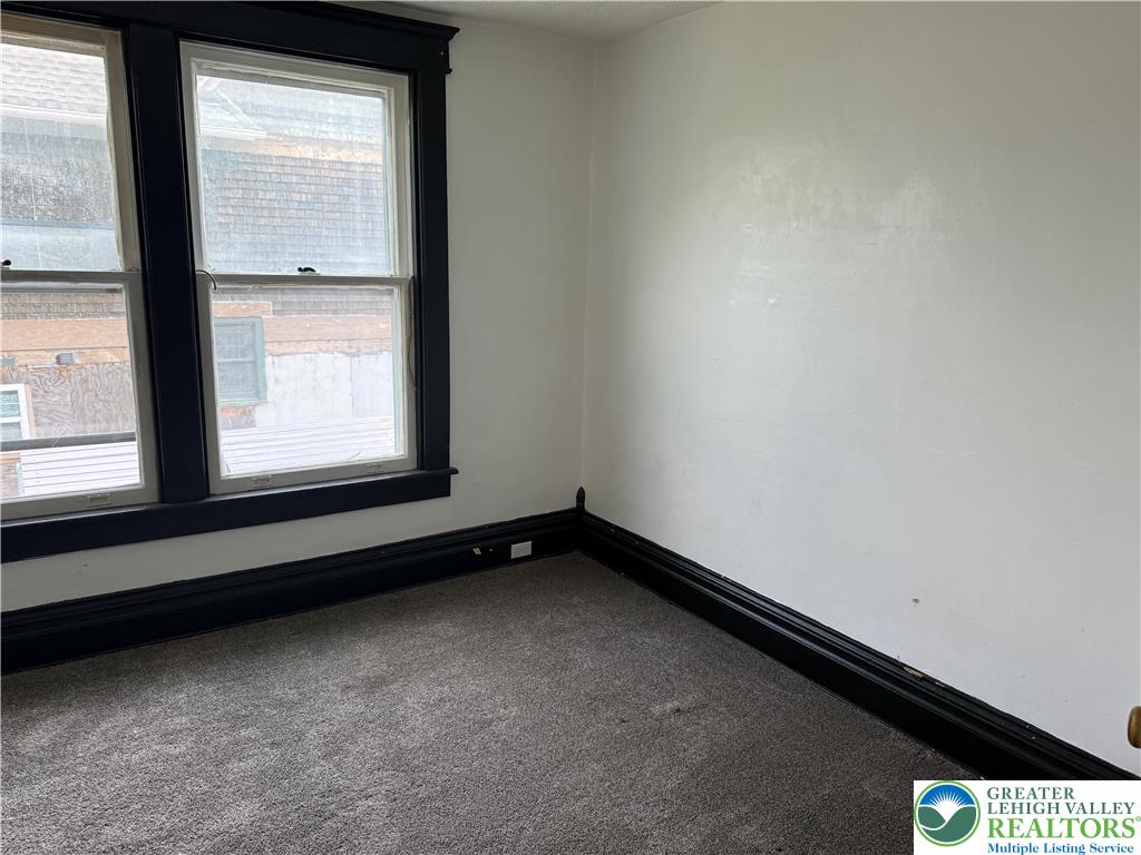 41 West Ridge Street Lansford, PA 18232 - Photo 22 of 40 Well-lit room with double-hung windows and soft carpet, ready for your personal touch.