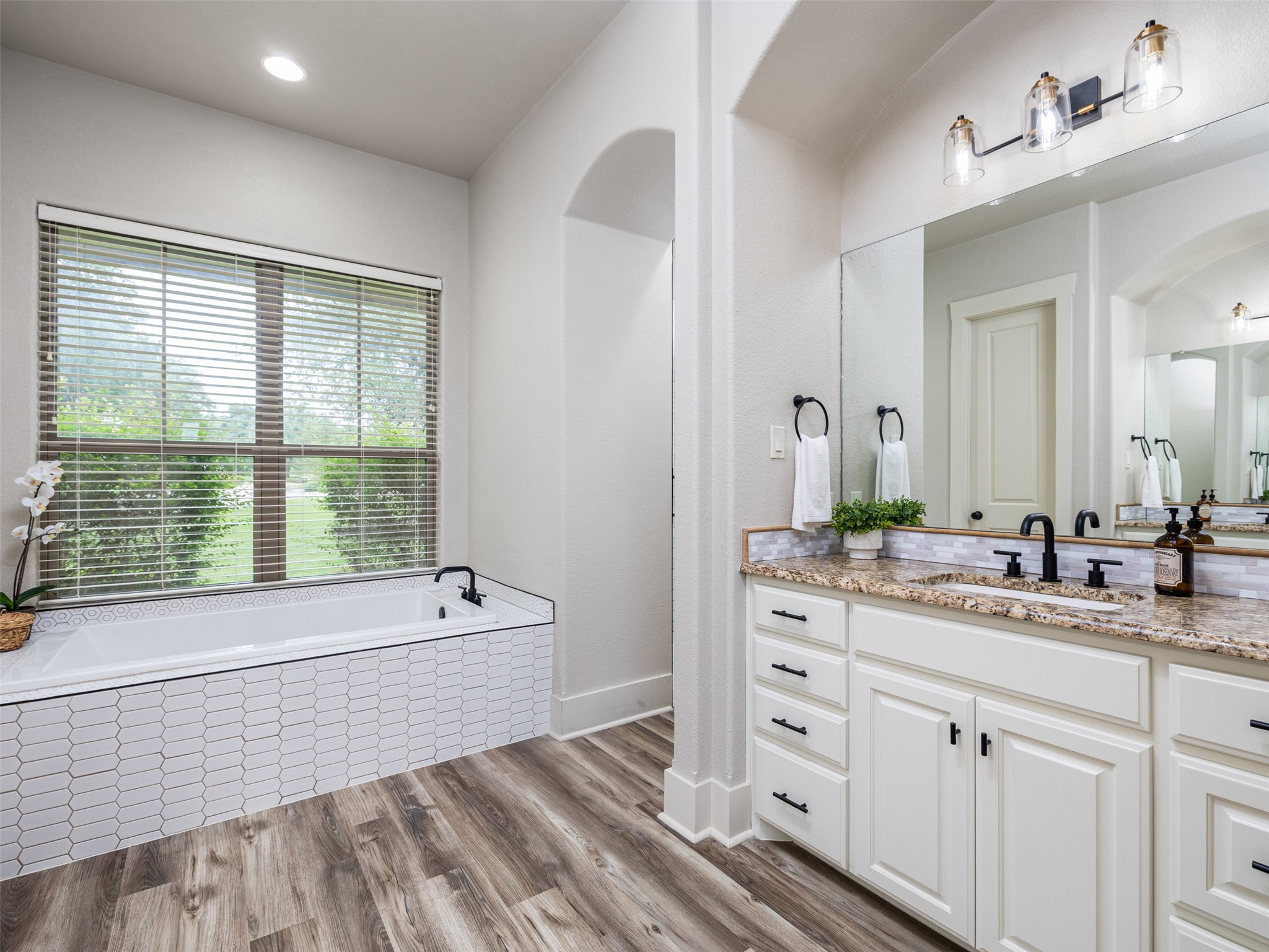 101 Aldea Street Georgetown, TX 78633 - Photo 12 of 40 The primary bathroom has 2 separate vanities and features updated light fixtures & hardware as well as the updated tile tub surround.