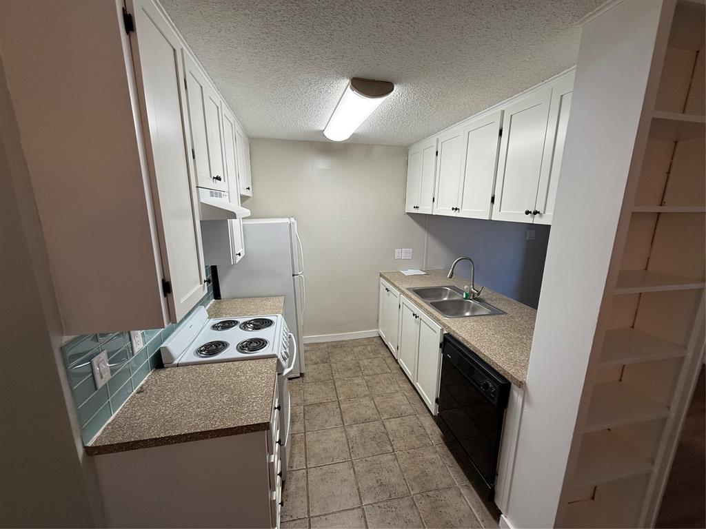 2408 Longview Street, Unit 108 Austin, TX 78705 - Photo 2 of 7 a kitchen with stainless steel appliances granite countertop a sink stove and white cabinets