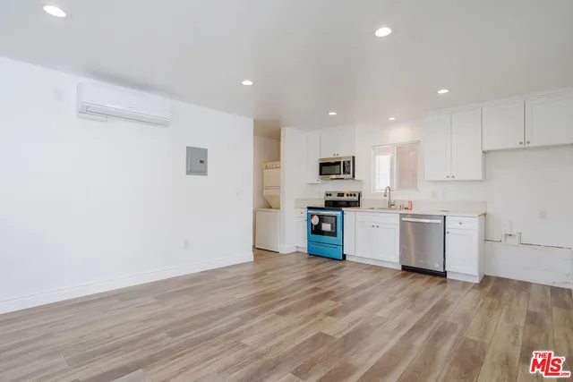 a kitchen with granite countertop a sink cabinets and stainless steel appliances