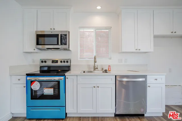a kitchen with white cabinets and stainless steel appliances
