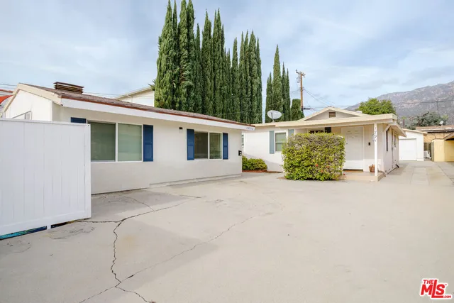 a view of a house with a yard and potted plants