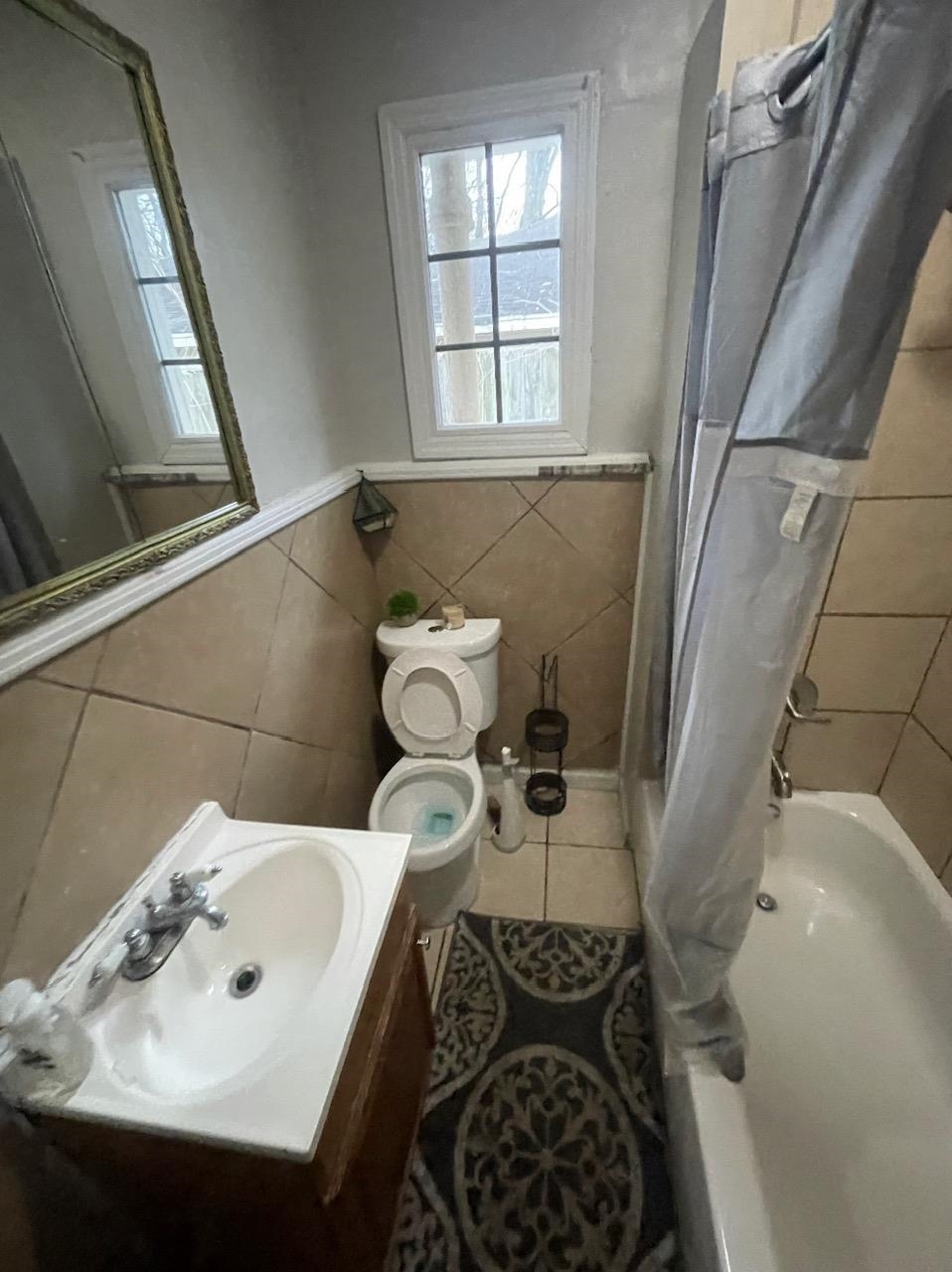 3564 Kendrick Road Memphis, TN 38108 - Photo 2 of 2 a bathroom with a sink and mirror with toilet
