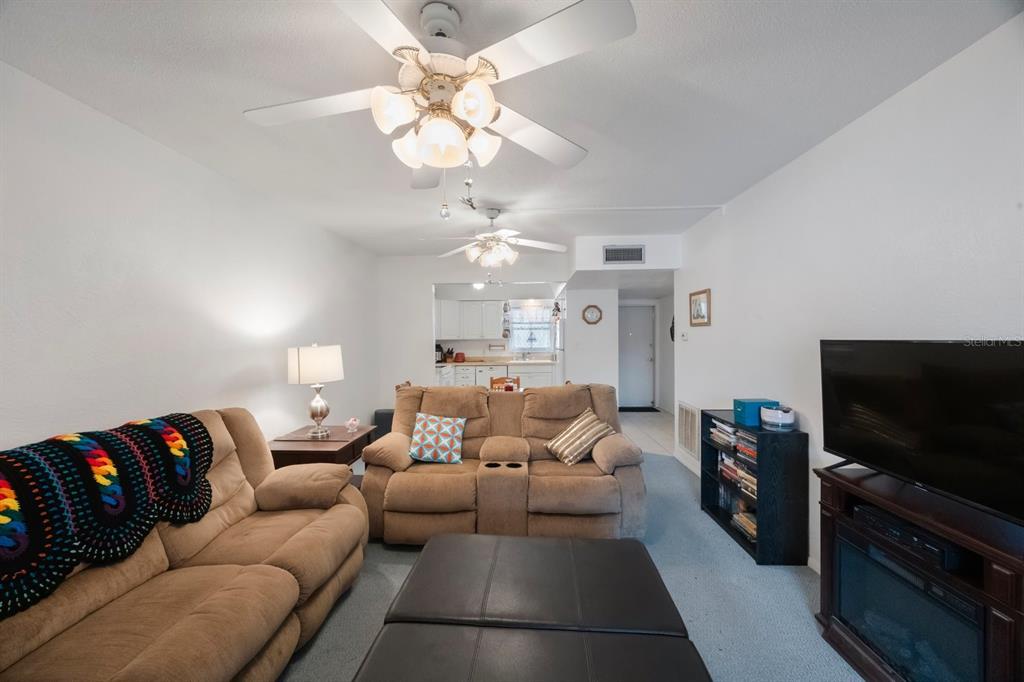 9945 47th Avenue North, Unit 203 St. Petersburg, FL 33708 - Photo 11 of 29 a living room with furniture and a flat screen tv