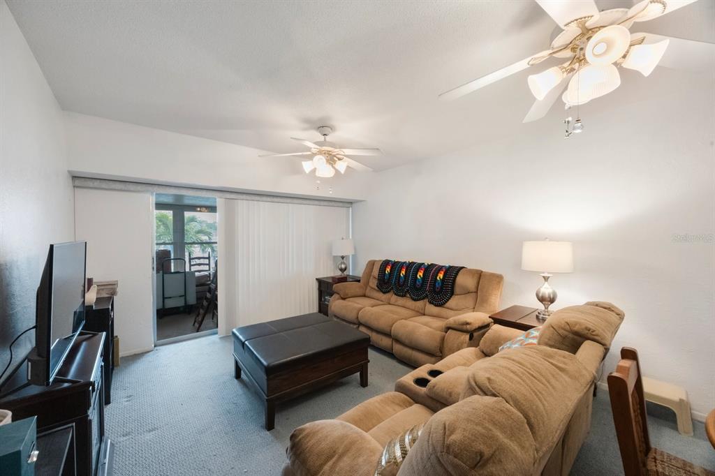9945 47th Avenue North, Unit 203 St. Petersburg, FL 33708 - Photo 13 of 29 a living room with furniture a lamp and a chandelier