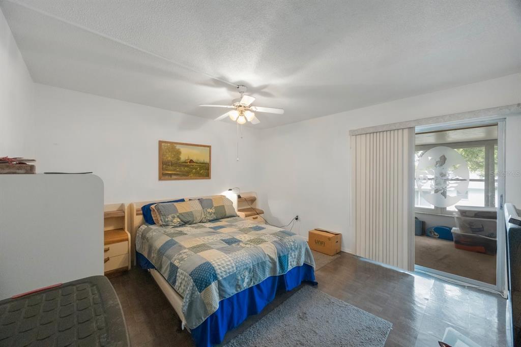 9945 47th Avenue North, Unit 203 St. Petersburg, FL 33708 - Photo 15 of 29 a bedroom with a bed and a chandelier