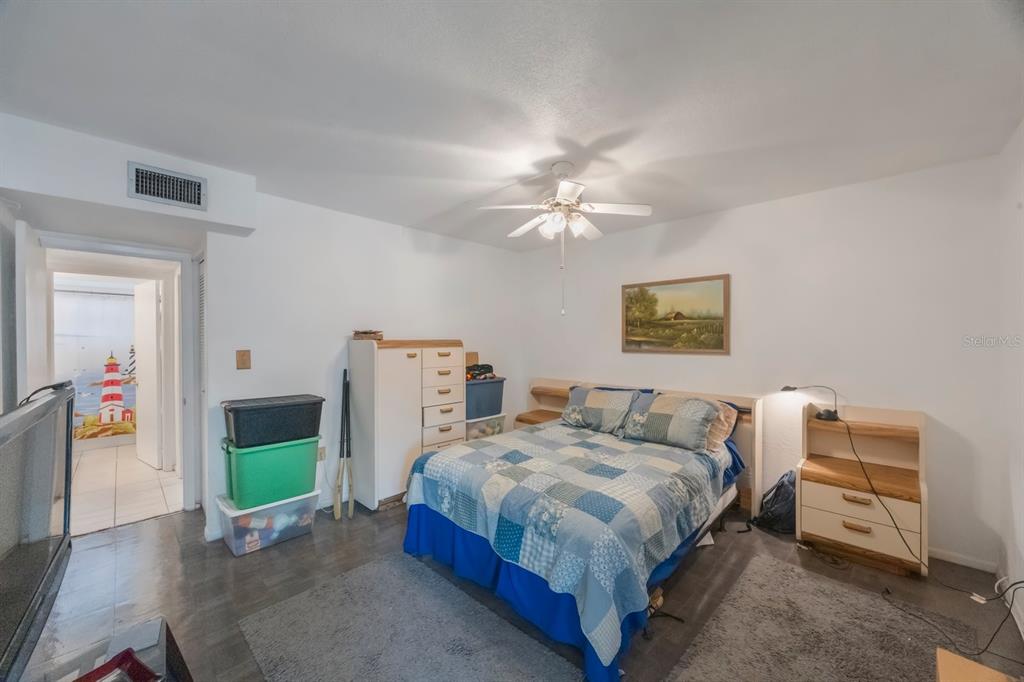 9945 47th Avenue North, Unit 203 St. Petersburg, FL 33708 - Photo 16 of 29 a bedroom with a bed and a chandelier