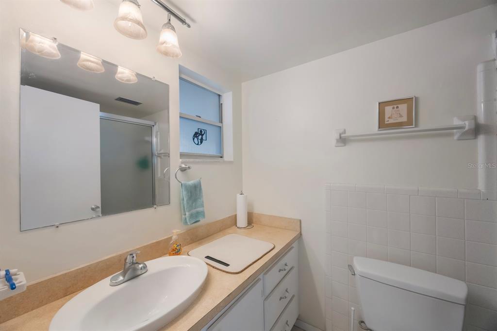 9945 47th Avenue North, Unit 203 St. Petersburg, FL 33708 - Photo 18 of 29 a bathroom with a sink a toilet and a mirror