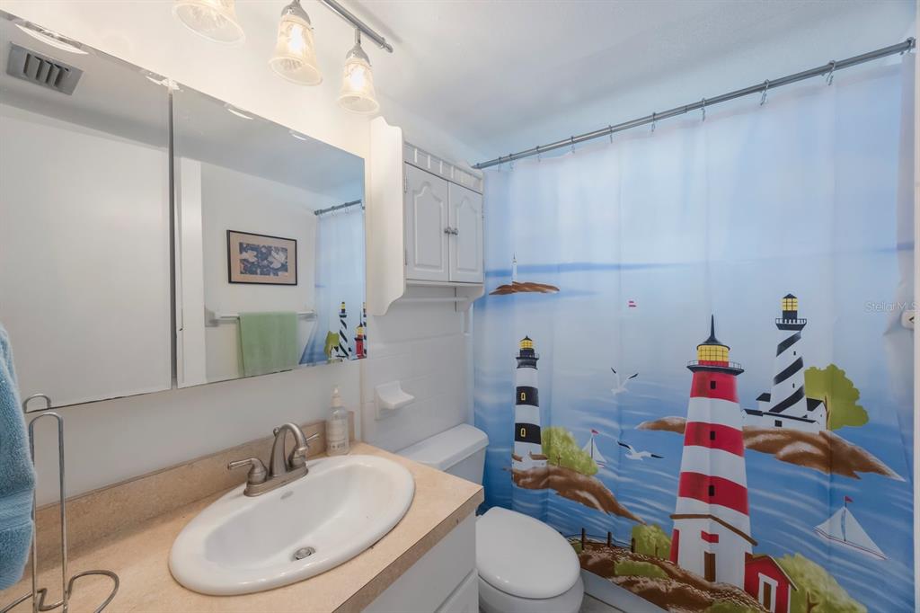 9945 47th Avenue North, Unit 203 St. Petersburg, FL 33708 - Photo 19 of 29 a bathroom with a sink toilet and vanity