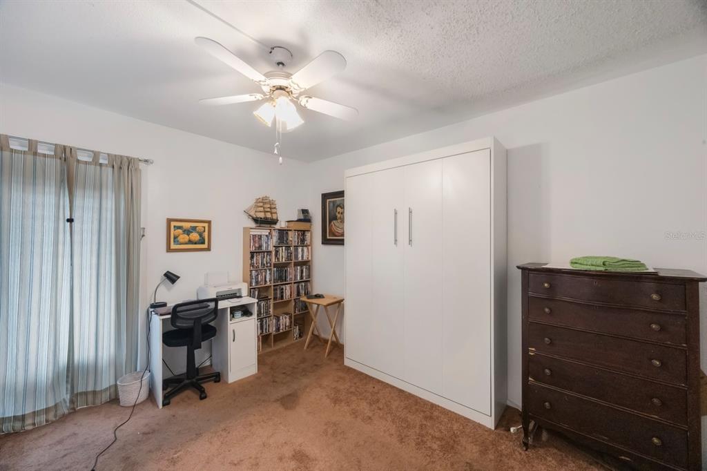 9945 47th Avenue North, Unit 203 St. Petersburg, FL 33708 - Photo 21 of 29 a view of a workspace with furniture and a window