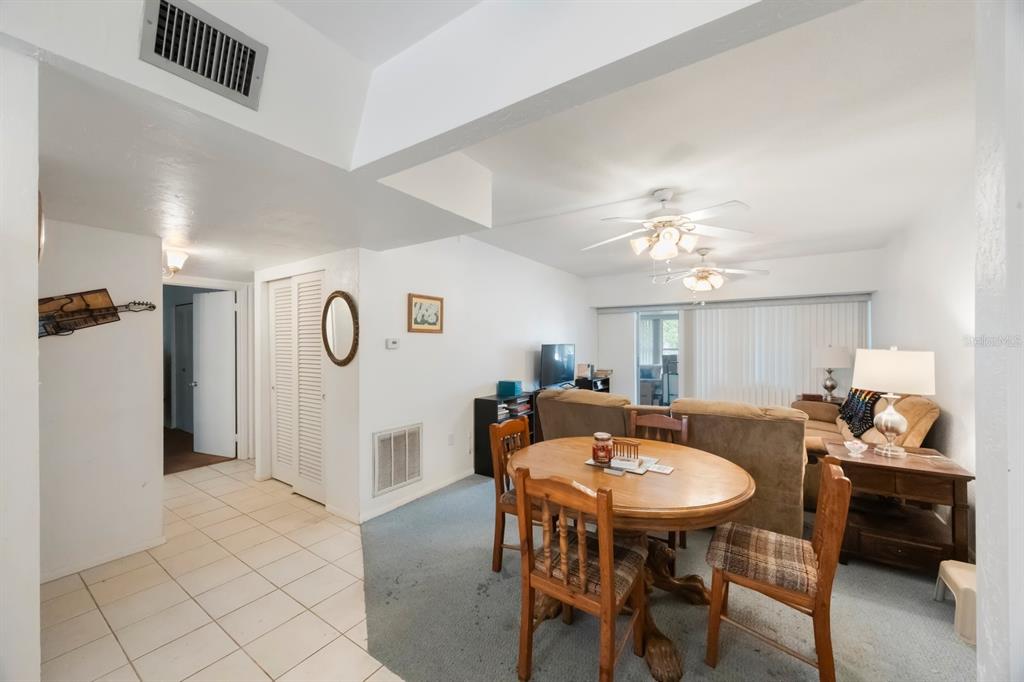 9945 47th Avenue North, Unit 203 St. Petersburg, FL 33708 - Photo 6 of 29 a view of a dining room with furniture and a chandelier