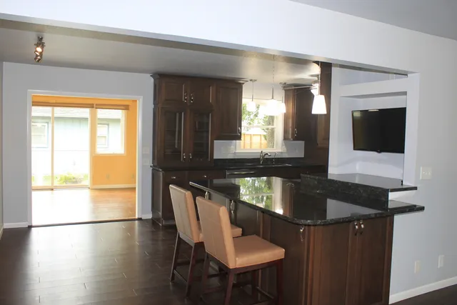 a kitchen with granite countertop a sink and a refrigerator