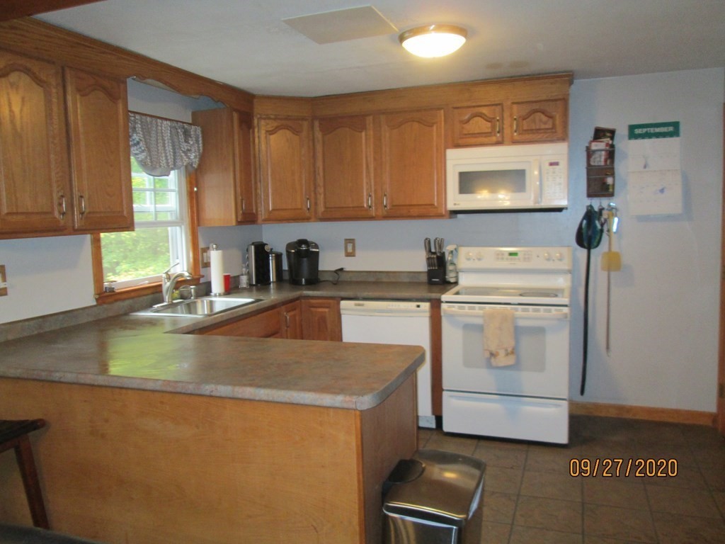 66 South Road Londonderry, NH 03053 - Photo 3 of 21 a kitchen with a sink a stove and cabinets
