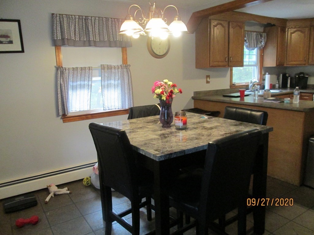 66 South Road Londonderry, NH 03053 - Photo 6 of 21 a kitchen with a table chairs and chandelier
