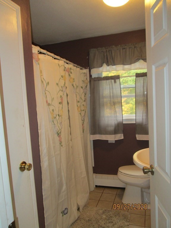 66 South Road Londonderry, NH 03053 - Photo 9 of 21 a bathroom with a toilet and a shower curtain