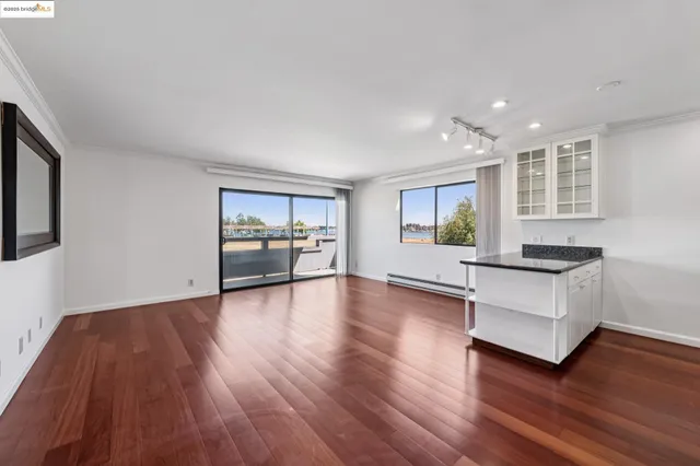 a living room with hard wood floors and a kitchen