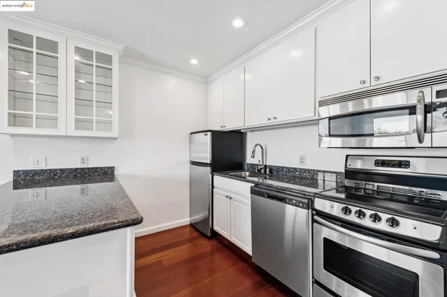 a kitchen with stainless steel appliances a refrigerator and a stove top oven
