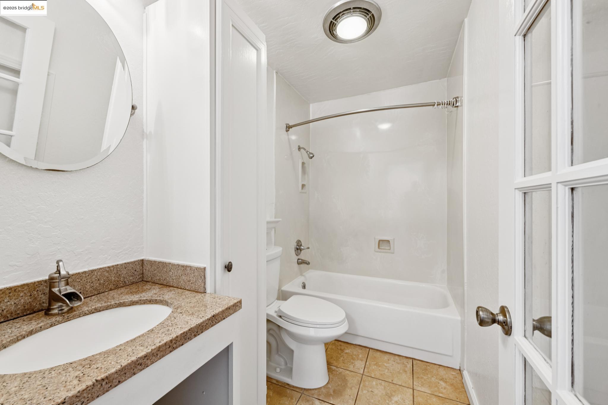 1 Embarcadero, Unit 161 Oakland, CA 94607 - Photo 27 of 31 Bathroom featuring shower / bath combination, vanity, and light tile patterned floors