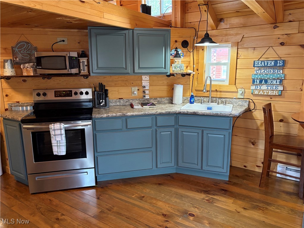 5919 Lake Road West, Unit 13 Ashtabula, OH 44004 - Photo 10 of 35 Kitchen featuring wood walls, stainless steel appliances, light countertops, a wood ceiling with exposed beams, and dark wood-style floors