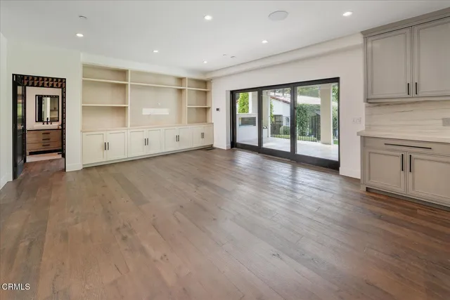 a large kitchen with stainless steel appliances a large counter top a sink a refrigerator and window