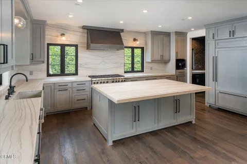 a view of an empty room with window and hardwood floor
