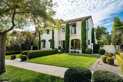 a view of a house with a big yard plants and large trees