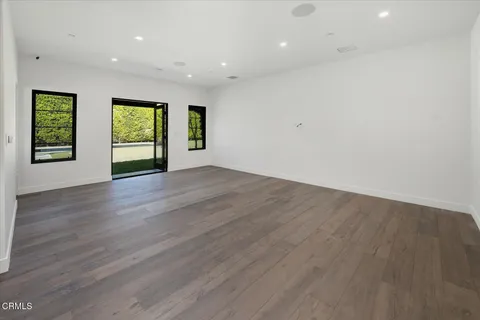 an aerial view of residential houses with outdoor space and trees