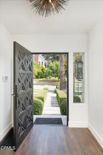 an empty room with wooden floor fireplace and windows