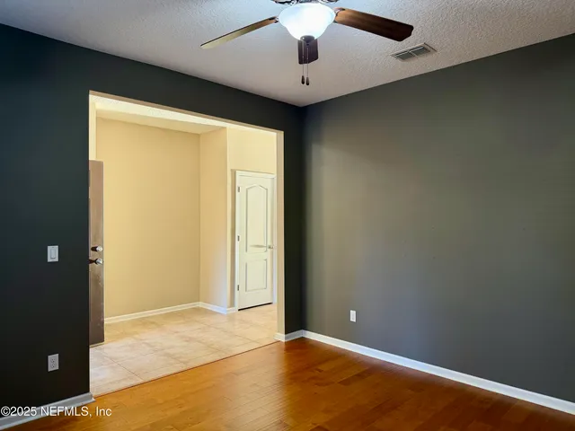 an empty room with a ceiling fan and painted walls