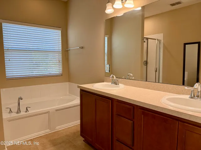 a bathroom with a tub sink and mirror