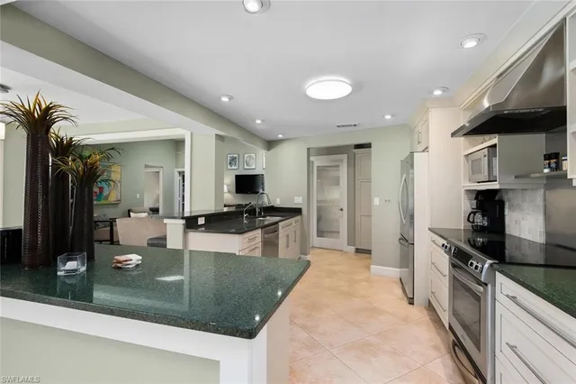 a large kitchen with stainless steel appliances granite countertop a lot of counter space and a dining table