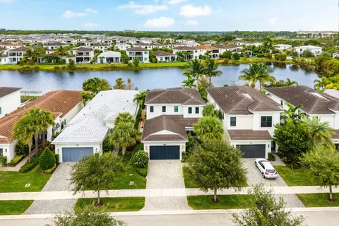 an aerial view of residential houses with outdoor space and lake view