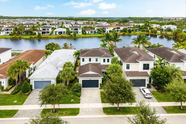 an aerial view of residential houses with outdoor space and lake view