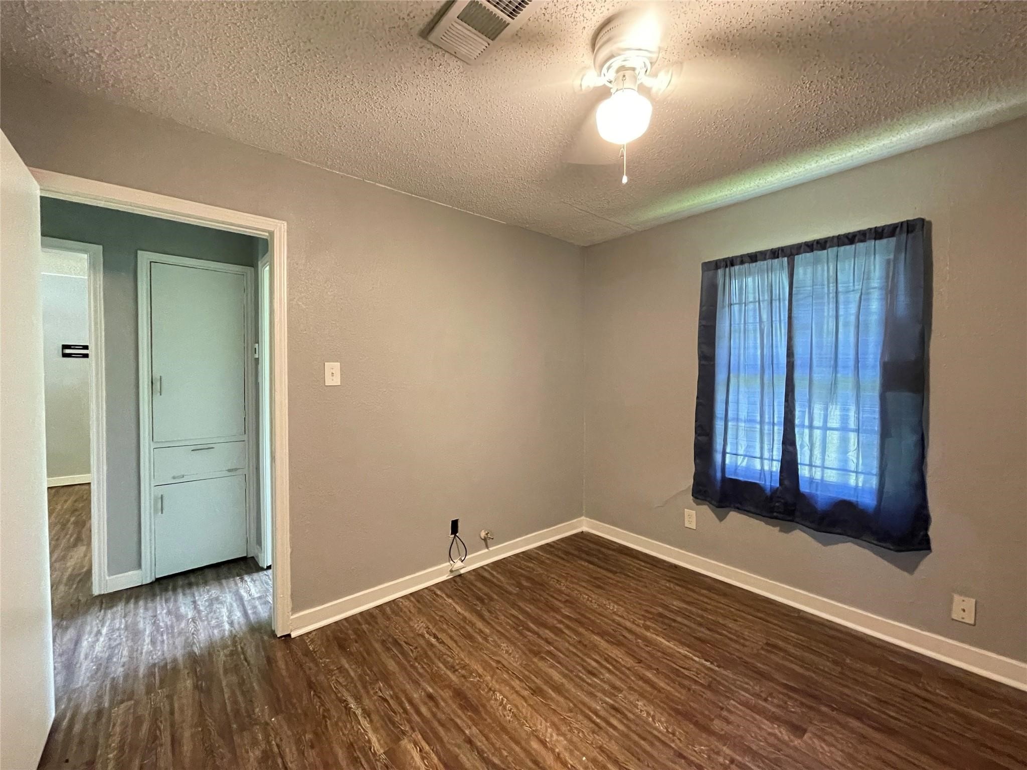 5213 Anzio Road Houston, TX 77033 - Photo 11 of 20 wooden floor in an empty room with a window