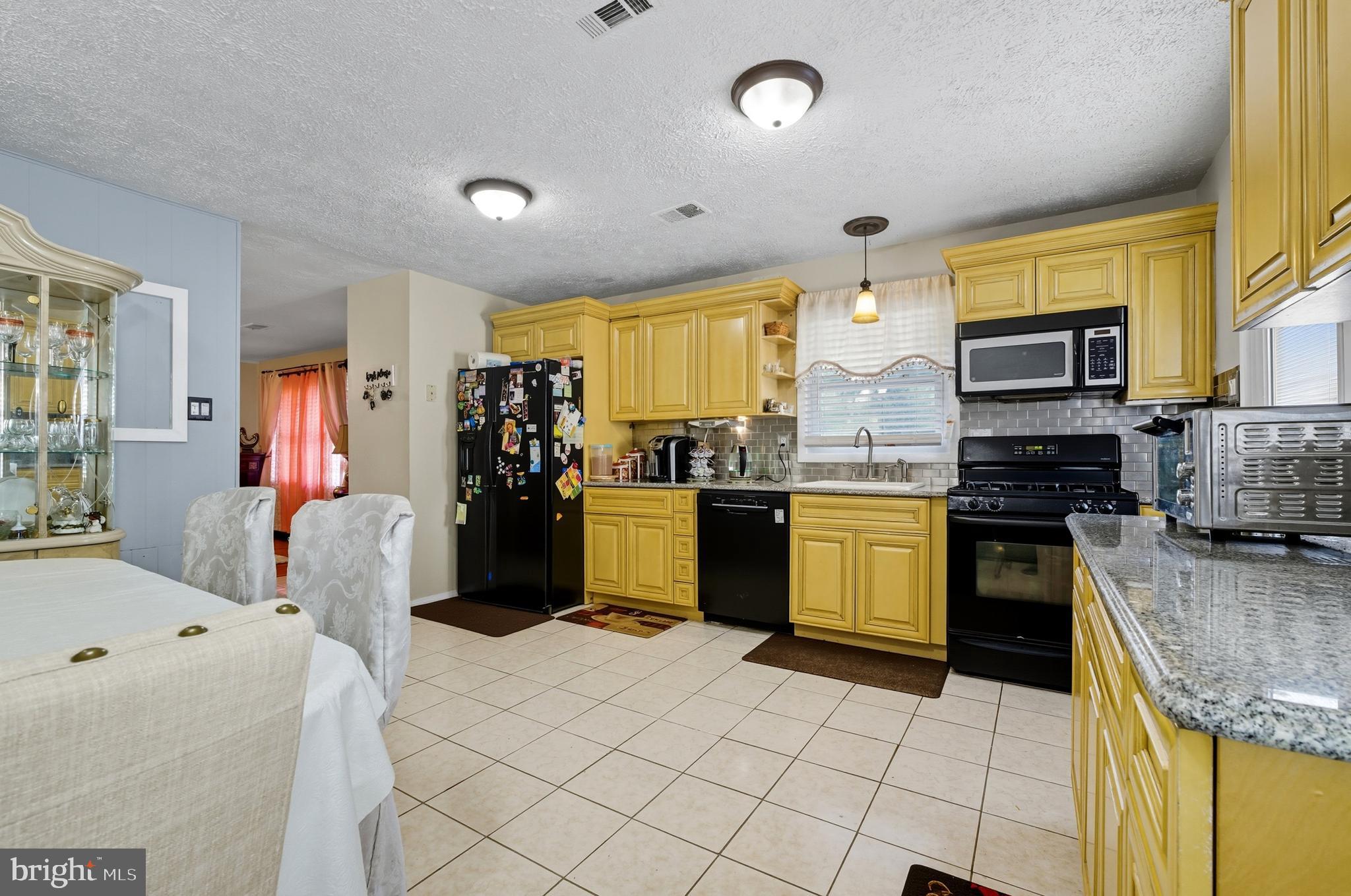 1311 Tenbrook Road Odenton, MD 21113 - Photo 18 of 37 a kitchen with granite countertop a stove and a refrigerator