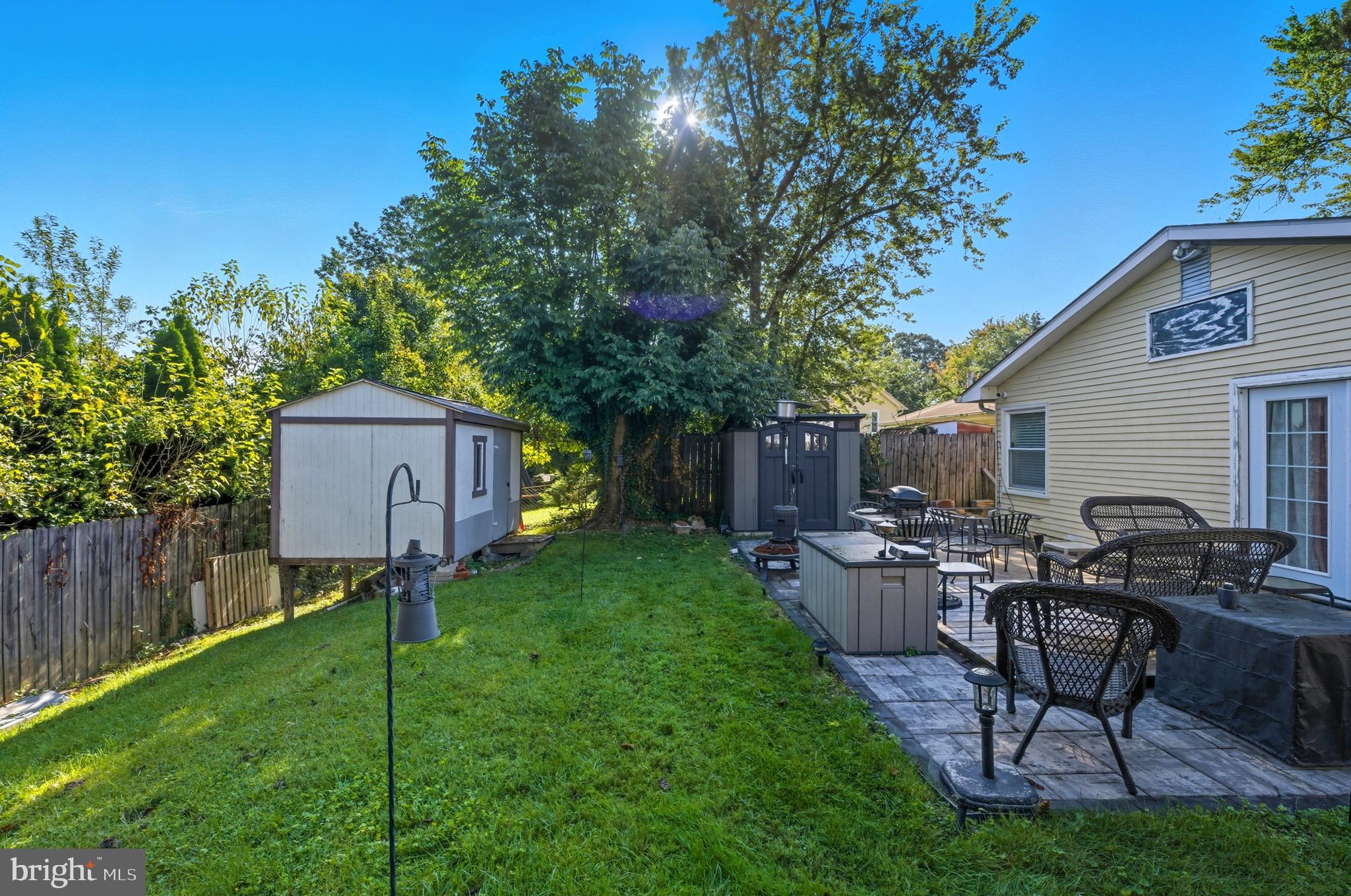1311 Tenbrook Road Odenton, MD 21113 - Photo 36 of 37 a view of a backyard with table and chairs potted plants and a large tree