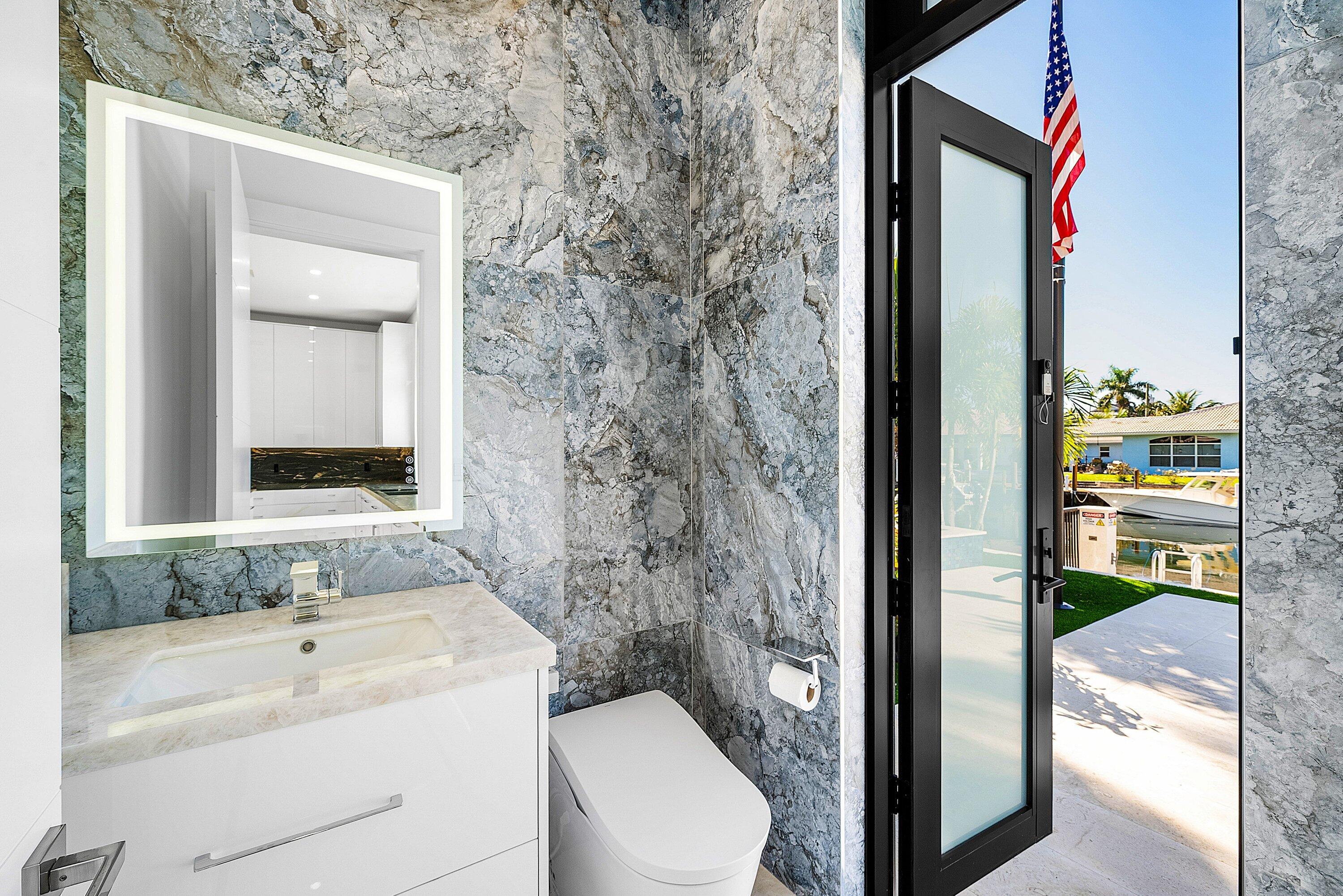2650 Northeast 48th Court Lighthouse Point, FL 33064 - Photo 25 of 86 a bathroom with a granite countertop sink and a mirror