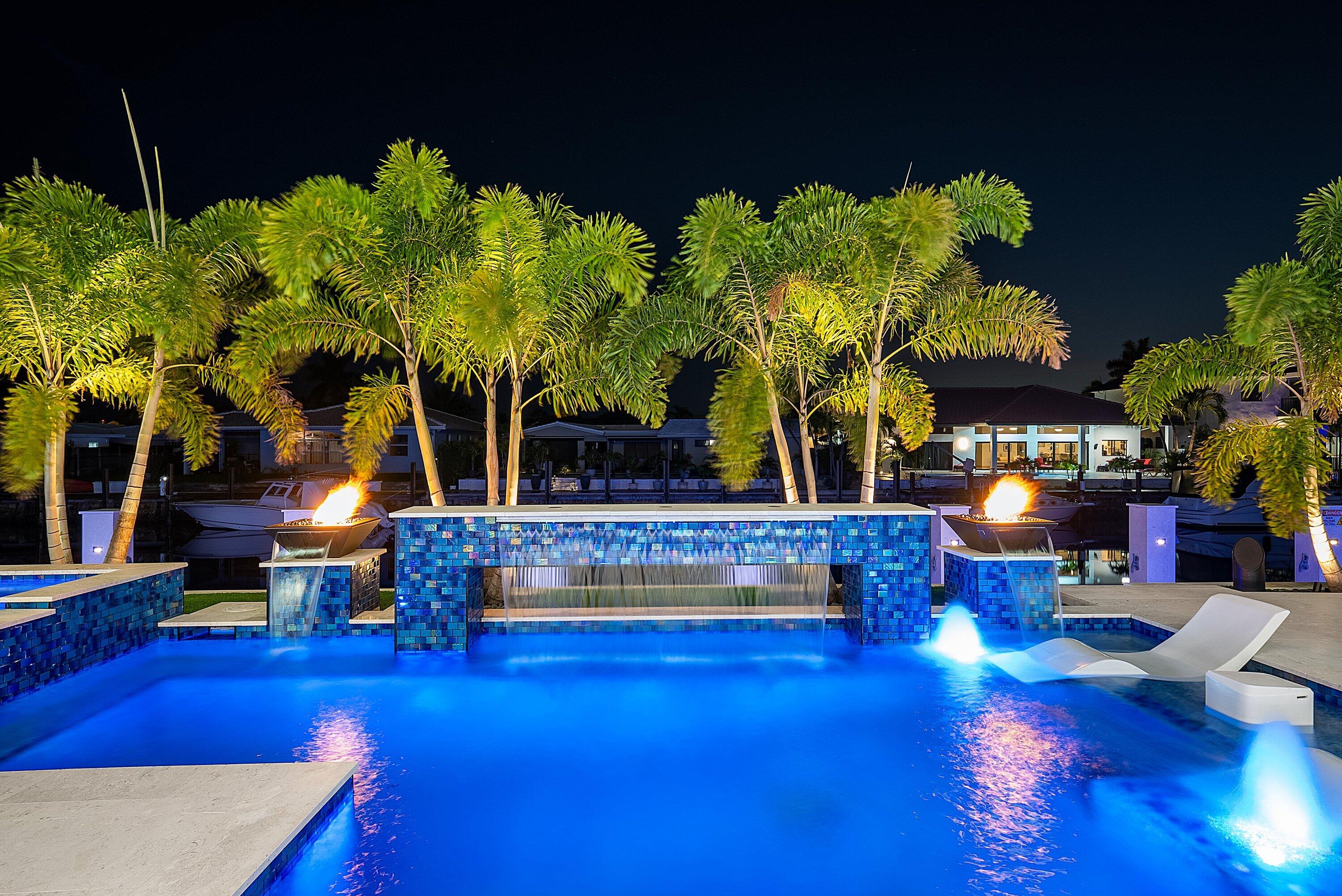2650 Northeast 48th Court Lighthouse Point, FL 33064 - Photo 77 of 86 a view of swimming pool with seating area and trees in the background