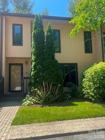 a front view of a house with a yard and potted plants