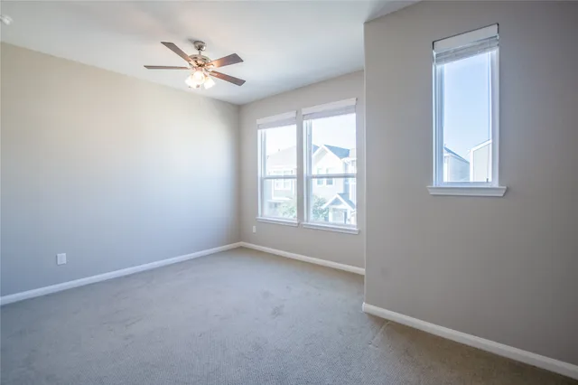 an empty room with a window and a fan