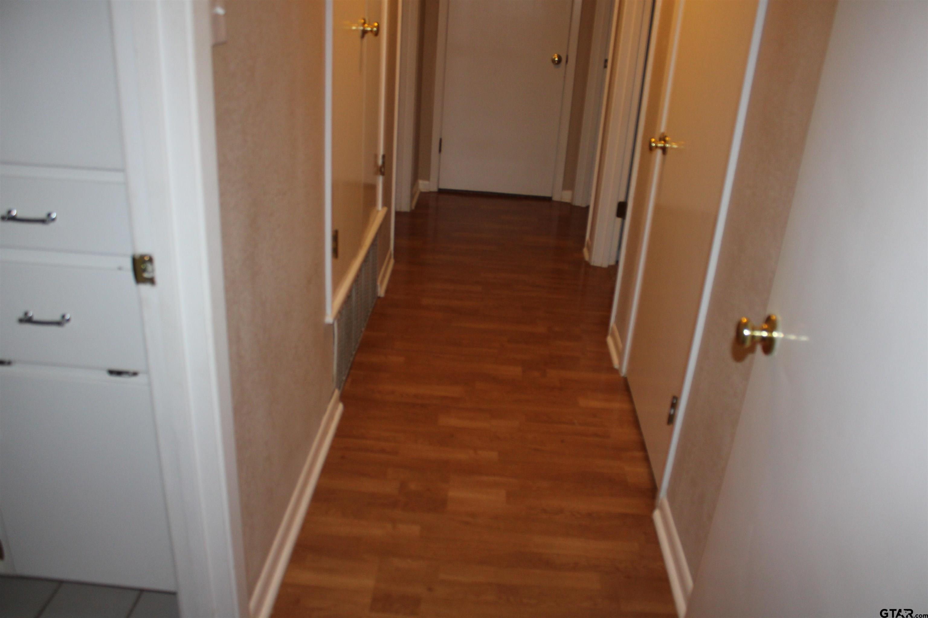 8202 Purdue Drive Tyler, TX 75703 - Photo 12 of 27 a view of a hallway with wooden floor and staircase