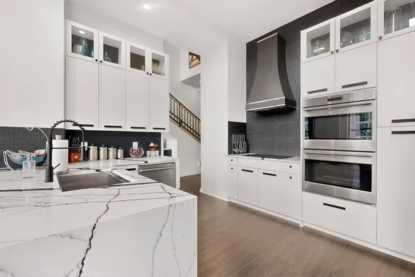 a kitchen with kitchen island granite countertop a stove and a sink