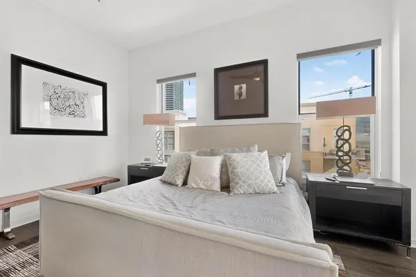 a bedroom with a bed and a lamp on dresser