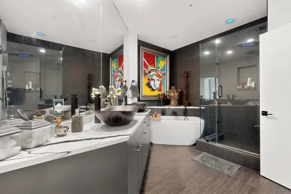 a bathroom with a double vanity sink mirror and bathtub
